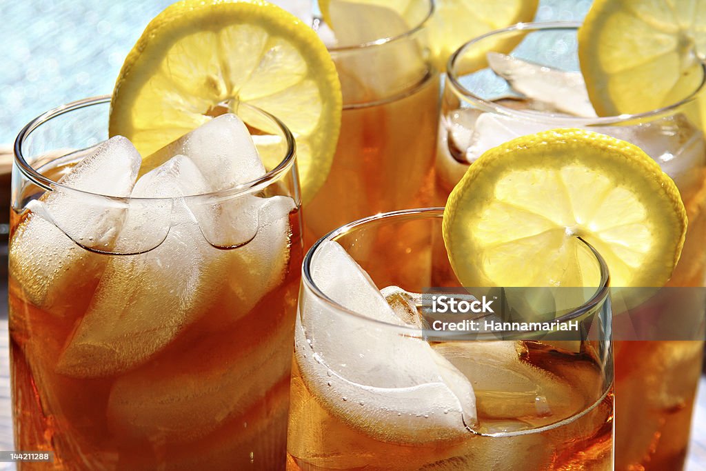 Ice tea Four glasses of lemon ice tea, outside by the pool. Ice Tea Stock Photo