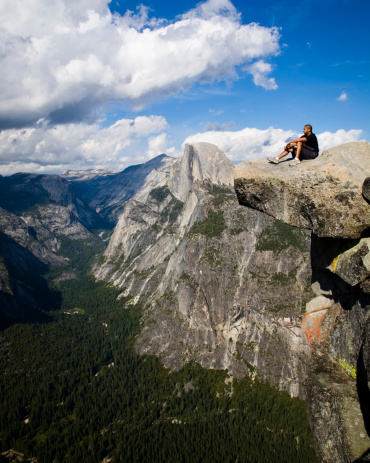 Sitting on a rock overlooking Yosemite Valley with Halfdome as the backdrop.