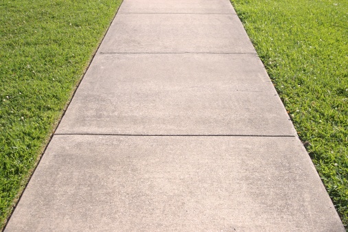 a concrete sidewalk with grass on both sides