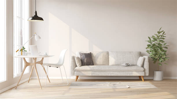 白い布製のソファ、フィドルの葉のイチジク植物、木製の作業机と椅子、モダンで豪華なクリーム色の壁と寄木細工の床の部屋、窓からの日光 - 家の中 ストックフォトと画像