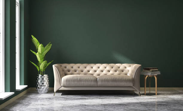 istock Cream colored leather sofa, brass side table and banana tree in modern and luxury green wall and marble floor room with sunlight from window 1442113785