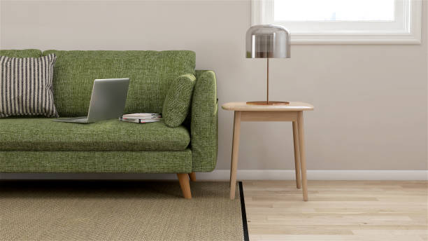 green fabric sofa, wooden side table with table lamp in modern and luxury and cozy creamed color wall and parquet floor with rug room with sunlight from window - side table imagens e fotografias de stock