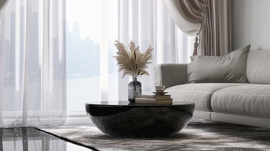 Modern design of gray fabric sofa with cushion and round black coffee table in luxury white wall and marble floor room with sunlight from window sheer curtain for interior decoration, lifestyle and architecture product display