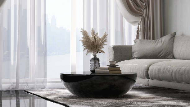 Modern design of gray fabric sofa with cushion and round black coffee table in luxury white wall and marble floor room with sunlight from window sheer curtain Modern design of gray fabric sofa with cushion and round black coffee table in luxury white wall and marble floor room with sunlight from window sheer curtain for interior decoration, lifestyle and architecture product display Translucent stock pictures, royalty-free photos & images