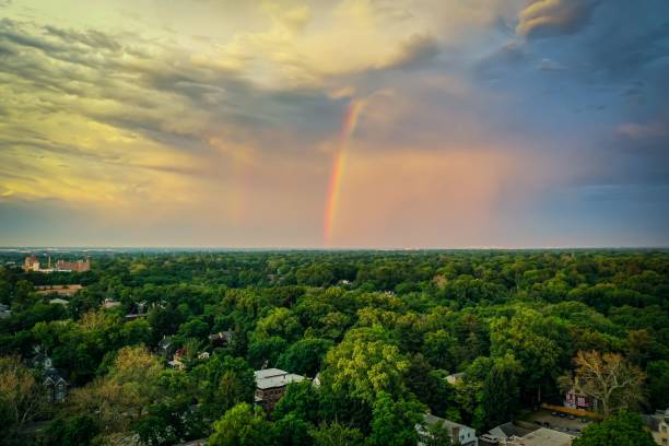 istock Double rainbow in the sky at sunset over a town all covered with greenery 1442115380