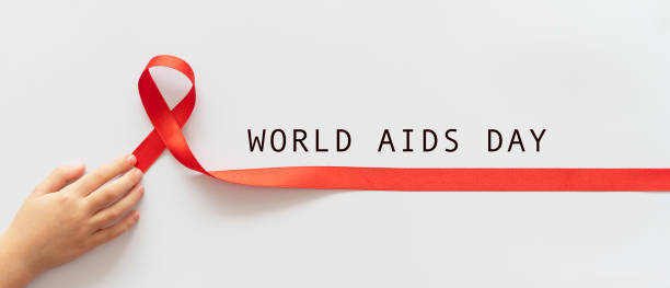 world aids day. child palms with red ribbon over white background. symbol of struggle against hiv, aids and cancer. concept of helping those in need. charity, donation, donor. mock up, blank, template, copy space - aids awareness ribbon imagens e fotografias de stock