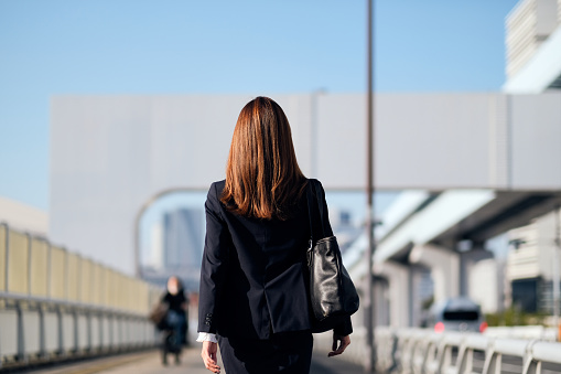 Rear view of confident businesswoman walking on the street