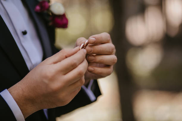 istock Groom holding wedding rings in his hands 1442117004