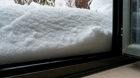 A closeup of the crystal clear white snow outside the open window