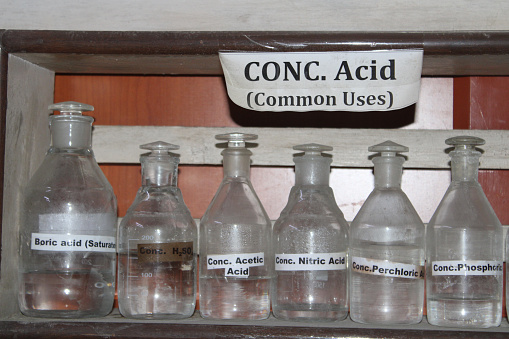 Transparent bottles filled with concentrated acid