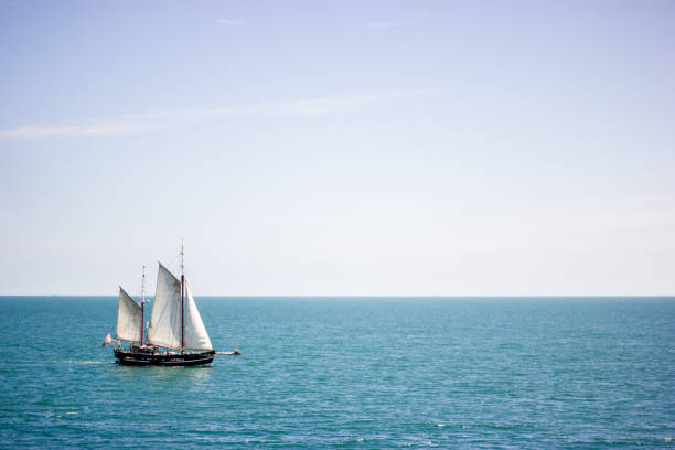 istock Sailing boat with white sails on a calm sea surface at daytime 1442117767