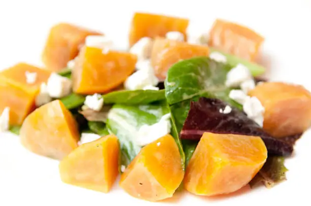 A closeup of a tasty salad with vegetables and feta cheese