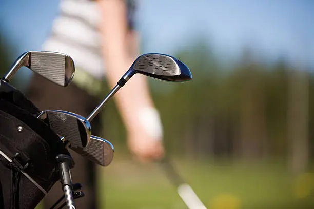Young golfer practising at range, focus on clubs. Click below to see more of my golf images