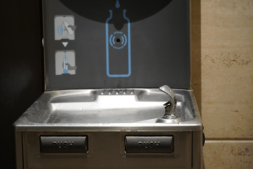 A closeup of a water refilling and drinking station at a public ar