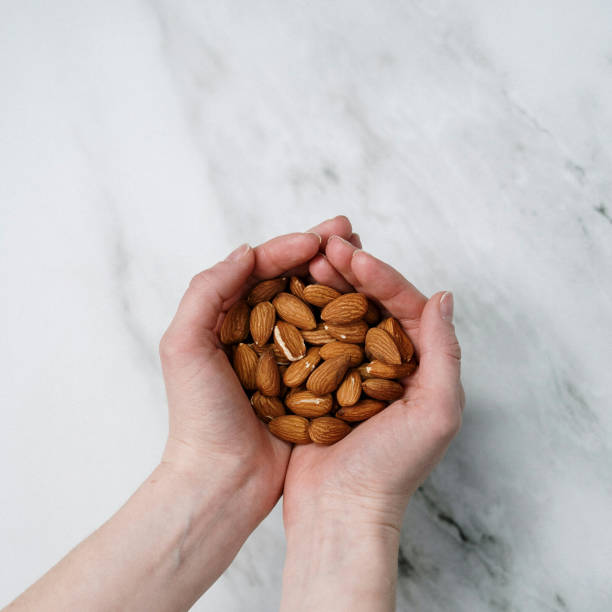istock Closeup shot of almonds on hand 1442119359