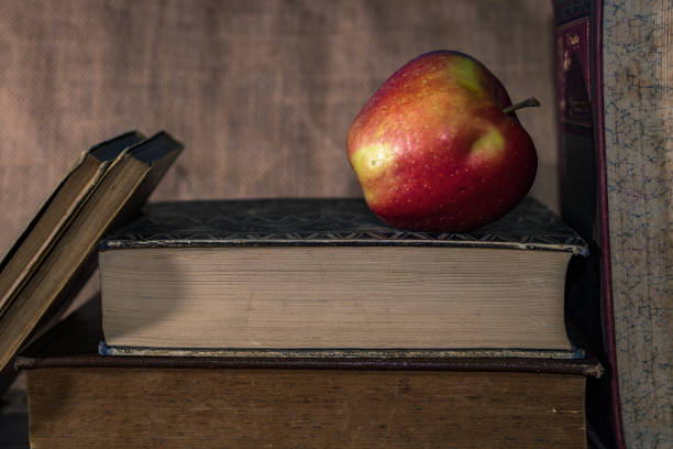 istock Closeup of a fresh ripe red apple on a closed book 1442119424