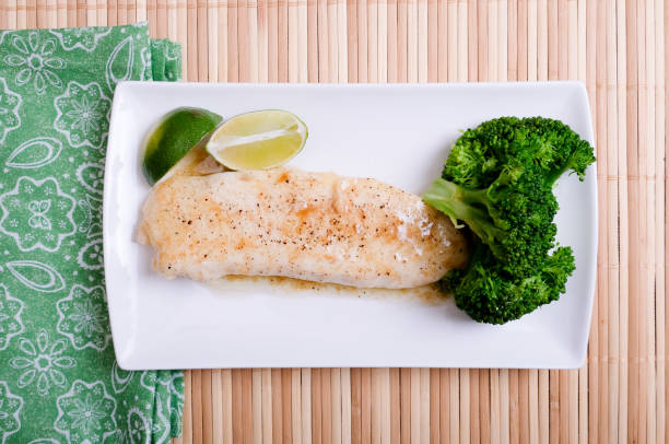 istock poached tilapia fillet with lemon sauce and brocolli 1442120000
