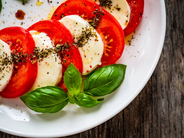 나무 배경에 카프리스 샐러드 - caprese salad mozzarella salad tomato 뉴스 사진 이미지