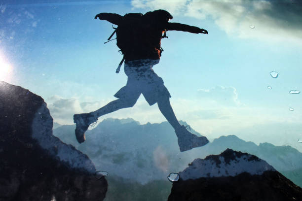 istock man in the alps jumping over the mountain peaks 1442122242