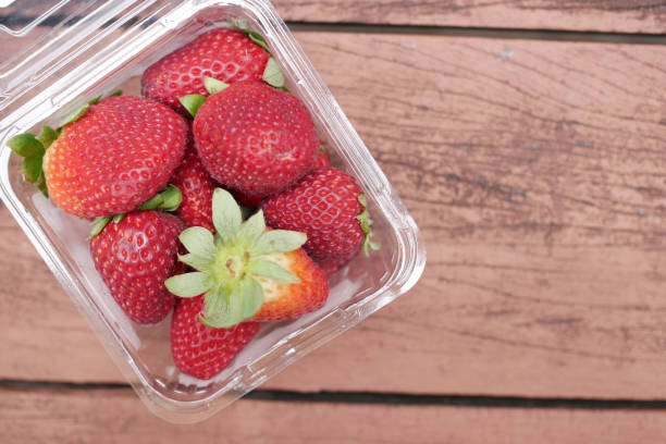 istock Ripe Red Strawberries in a plastic container on table 1442122451