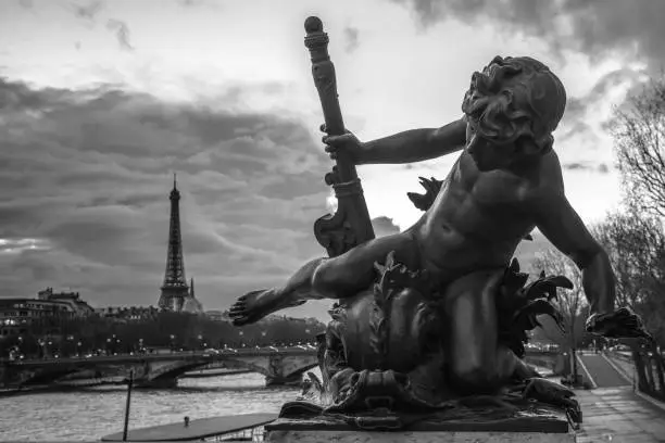 Photo of Grayscale shot of the Bronze Cherub statue in Paris
