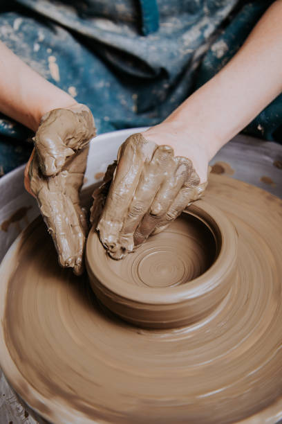 Woman hands working on pottery wheel and making a pot. Woman Making Clay Craftsman Skill Concept ceramic stock pictures, royalty-free photos & images