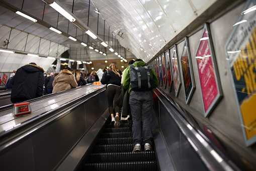 London, United Kingdom – November 01, 2021: A group of people leaving the subway on an escalator in London, the UK