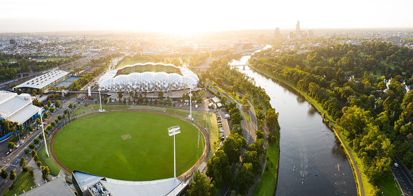 Melbourne, Australia – February 07, 2020: Melbourne Australia February 2nd 2020 : Aerial panoramic view in golden warm dawn light of the AAMI Stadium and rowers on the Yarra River in Melbourne