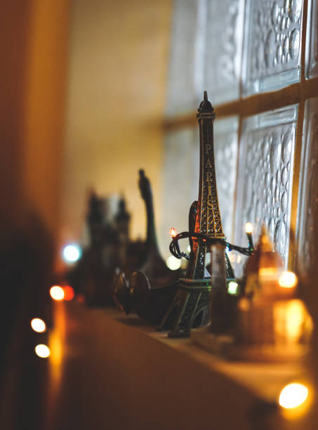 istock Selective focus of a small Eiffel Tower souvenir on the windowsill decorated with lights 1442123076