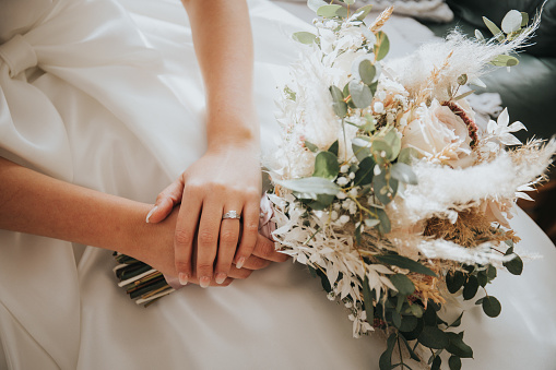 A closeup shot of a bride holding a bouquet