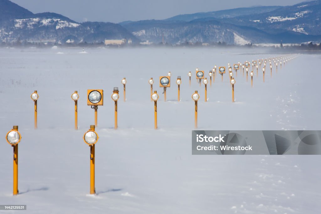 Landing lights on a runway in winter Landing lights on a runway in winter in Graz, Austria Airport Stock Photo