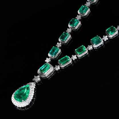 A necklace with green emeralds isolated on a black background