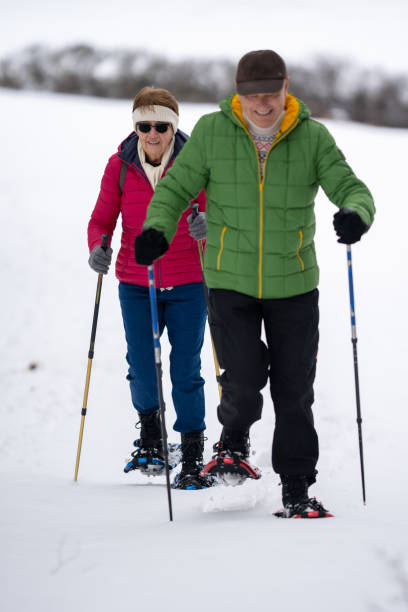 istock cheerful senior couple snowshoeing 1442126244