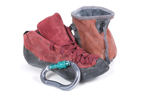Rock climbing gear including a shoe, carabiner and chalk bag.