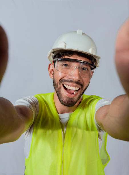 lustiger bauingenieur, der isoliert ein selfie macht, ingenieur, der isoliert ein selfie macht. ansicht eines männlichen ingenieurs, der isoliert ein selfie macht, lächelnder männlicher ingenieur, der ein selfie macht und in die kamera schaut - attractive male men humor looking at camera stock-fotos und bilder