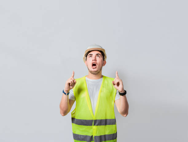 istock Amazed engineer pointing at an advertisement. Concept of an engineer with astonished face pointing at blank space, Amazed engineer man pointing up, Surprised young architect pointing up 1442131053