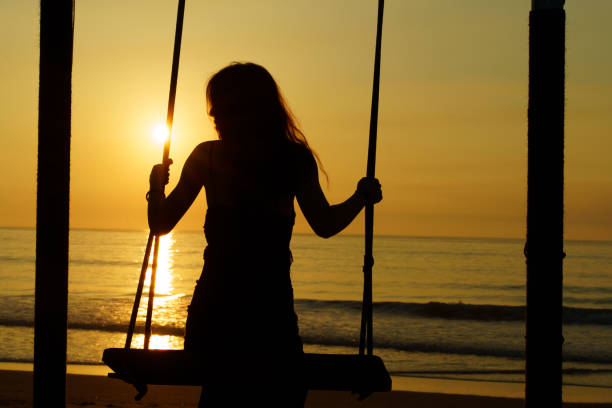 Young Asian women swing on the beach