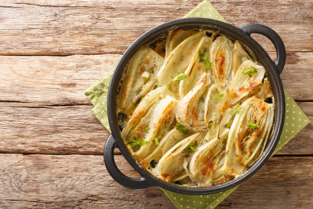 Italian food Parmesan Fennel Gratin closeup on the pan. Horizontal top view Italian food Parmesan Fennel Gratin closeup on the pan on the wooden table. Horizontal top view from above fennel stock pictures, royalty-free photos & images