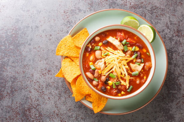 istock Chicken taco soup cooked in fragrant broth with beans, corn, tomatoes served with lime and tortilla chips close-up in a plate. Horizontal top view 1442134165