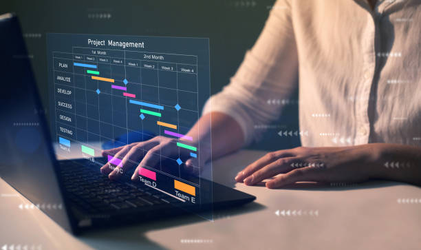 istock Project manager working on laptop and updating tasks and milestones progress planning with Gantt chart scheduling interface for company on virtual screen. 1442139030