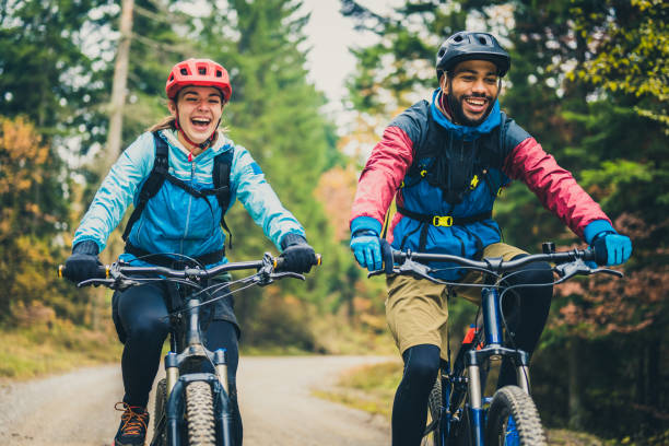 istock Man and woman riding mountain bikes in forest 1442139141