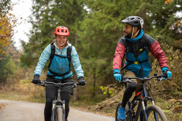 istock Man and woman riding mountain bikes in forest 1442139762