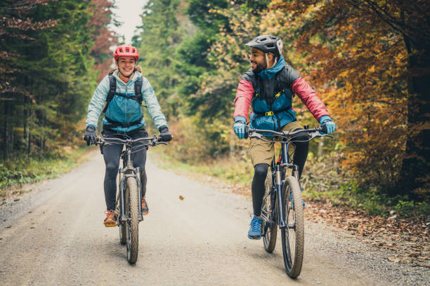 istock Man and woman riding mountain bikes in forest 1442139890