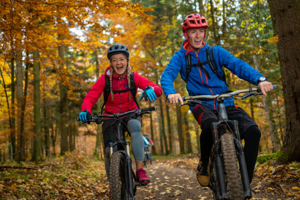 istock Man and woman riding mountain bikes in forest 1442139914