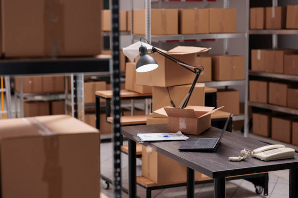 istock Empty storehouse with nobody in it equipped with tall shelves full with cardboard boxes ready for delivery 1442139928