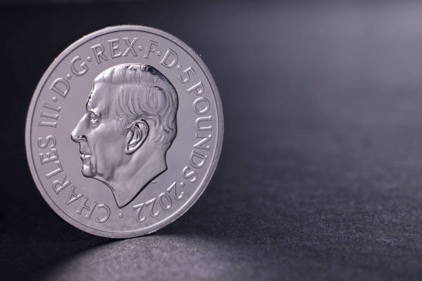 Haverfordwest, Wales - November 5, 2022: Studio shot of the first coin depicting King Charles III, with a face value of Five Pounds. Produced by the British Royal Mint to commemorate his ascension to the throne, the obverse shows the king facing left and the reverse shows the late Queen Elizabeth II