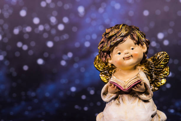 istock angel with a book on a night sky with stars 1442146771