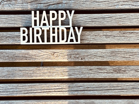 Text Happy birthday lying on weathered planks