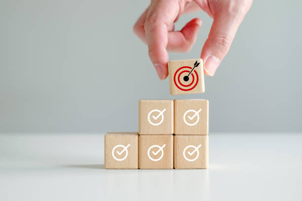 istock Checklist, Task list, Survey and assessment, Quality Control, Goals achievement and business success. To do list. Check mark and Hand holding dartboard from top of wooden stacks. 1442148855