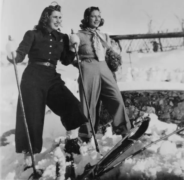 Young Women enjoying skiing together in the mountains. Winter Holidays on European Alps, 1935.